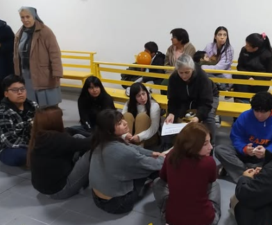 Encuentro de Pentecostés Joven en la Capilla Don Bosco de Puerto Deseado, con jóvenes sentados en círculo compartiendo una dinámica de reflexión pastoral