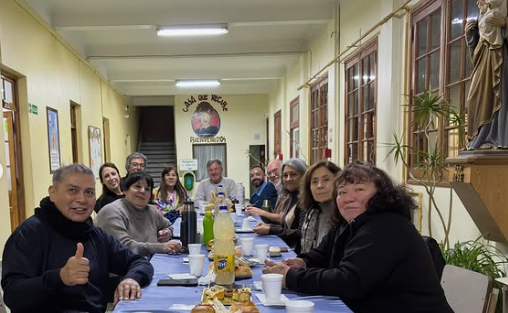 Exalumnos salesianos del ISSJ reunidos en una mesa compartiendo la alegría del encuentro en los pasillos del colegio en Puerto Deseado.
