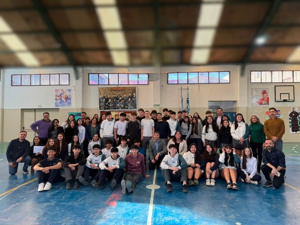 Estudiantes de 5to año Victoria Fernández y Aimar Pascua presentando el proyecto del Centenario del Instituto Salesiano San José en la banca del vecino.